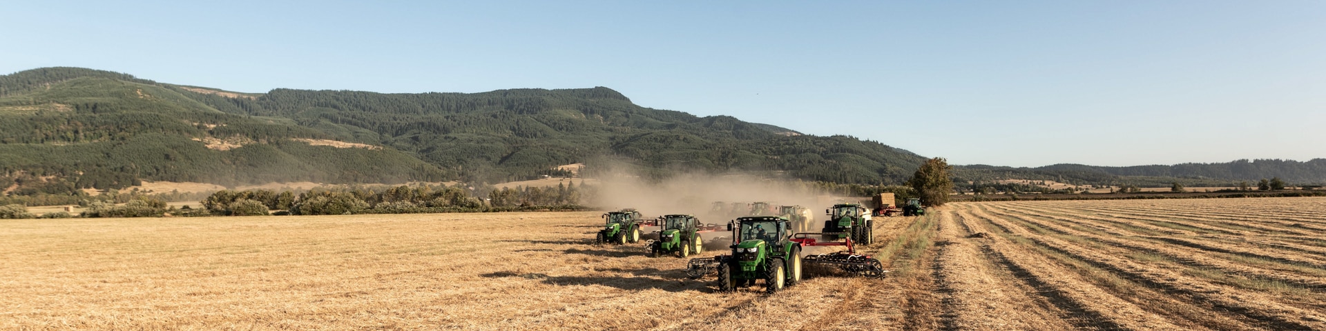 several tractors in hay field for meet our family business page